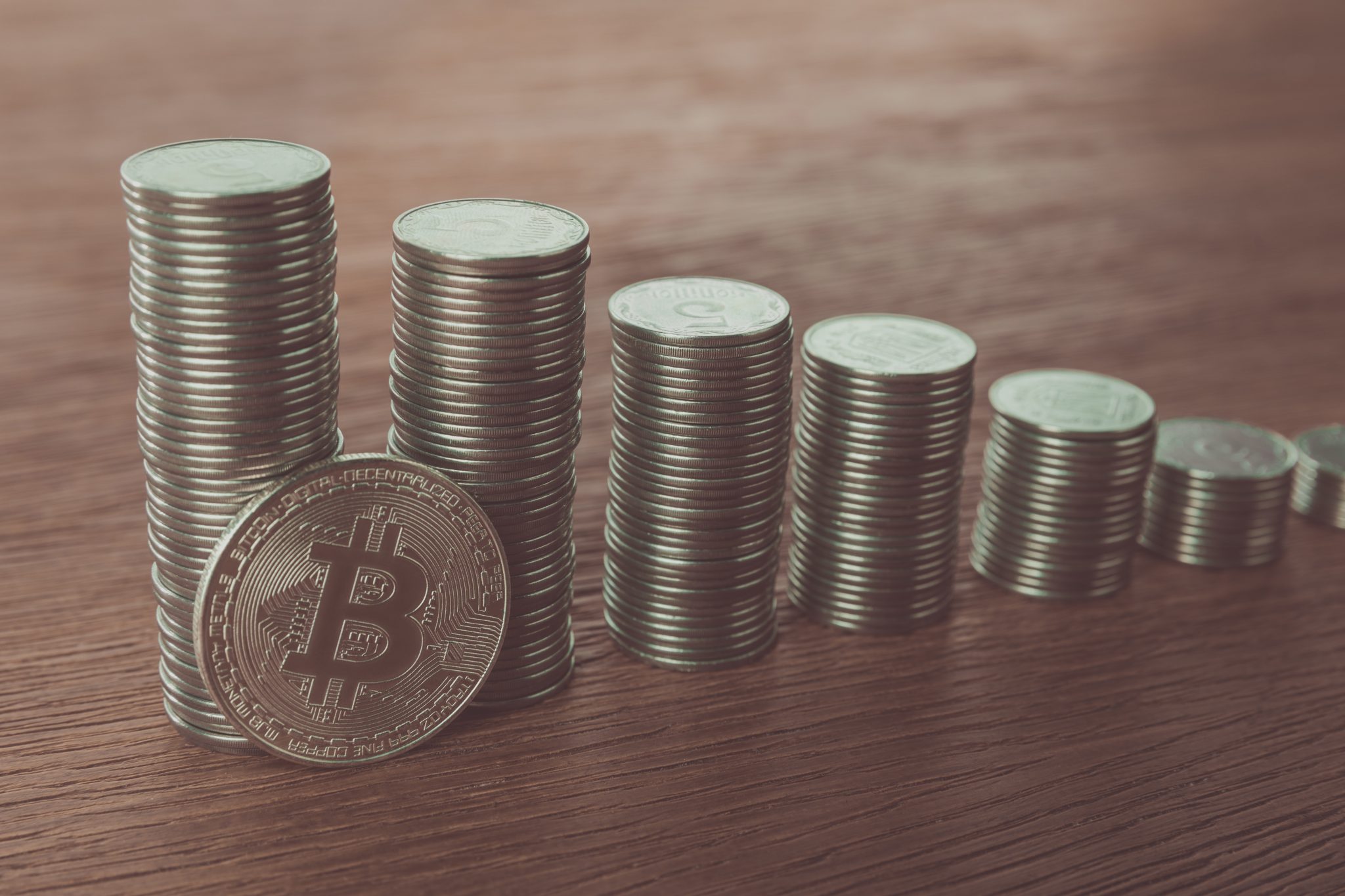 bitcoin near stacks of coins on tabletop, saving concept